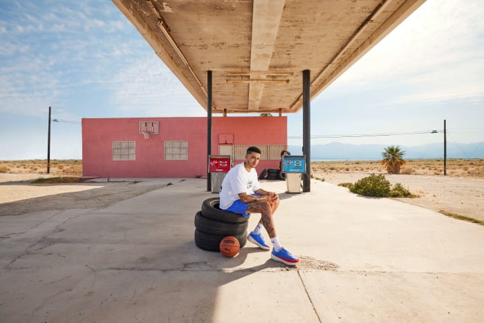 Kyle Kuzma models PUMA apparel at a gas station.